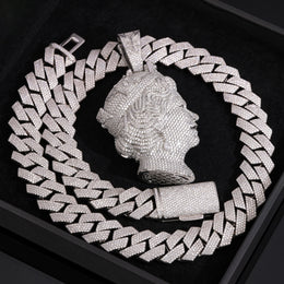 Silver-tone iced queen portrait pendant in a flat lay on a black surface