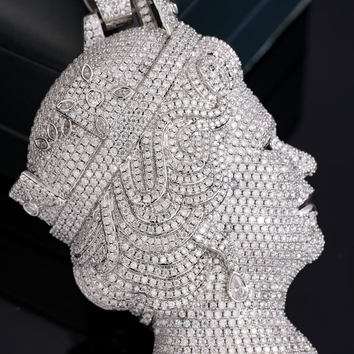 Close-up of the silver-tone queen portrait pendant showing pavé stones and decorative details