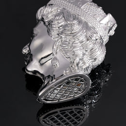 Silver-tone queen portrait pendant showing sculpted curls and the open lattice base