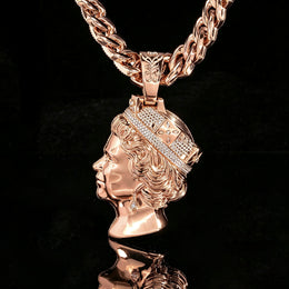 Rose-gold-tone queen portrait pendant showing the polished sculpted side against black