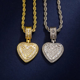 Gold and silver baguette iced double heart pendants on black fabric