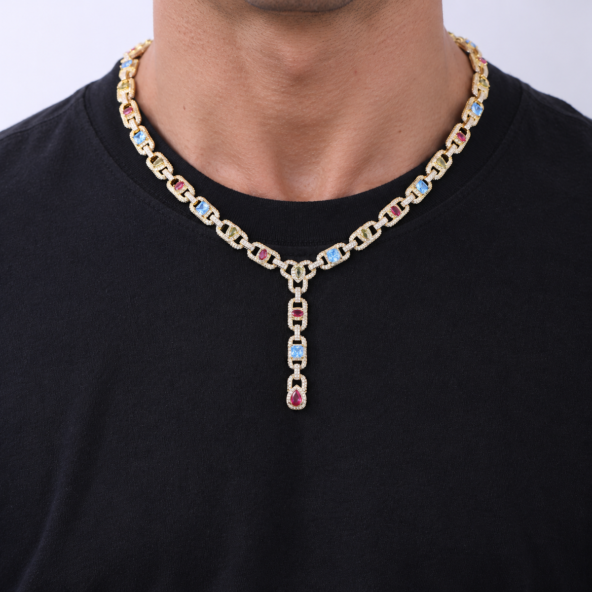 Adult model wearing a gold-tone multicolor lariat necklace over a black crew-neck shirt