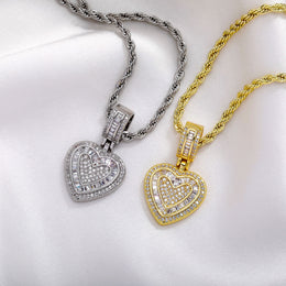 Gold and silver baguette iced double heart pendants on white fabric