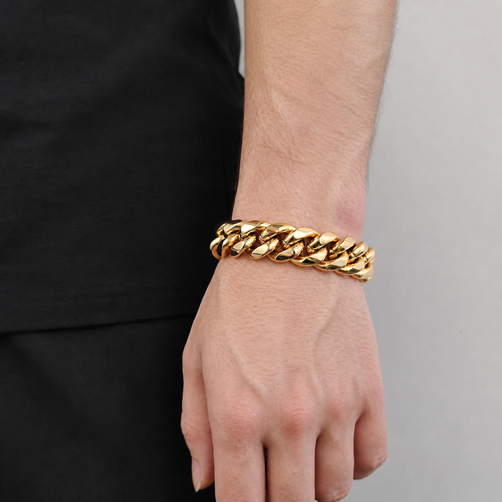 Gold-tone wide Cuban link bracelet worn on the wrist beside black clothing