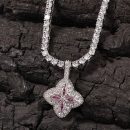 Pink four-leaf clover pendant displayed against dark textured wood