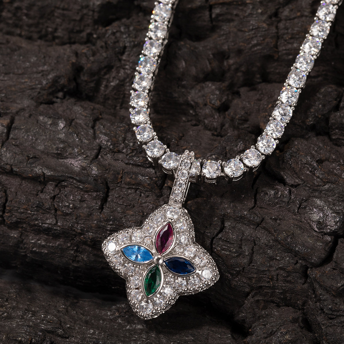 Multicolor four-leaf clover pendant displayed against dark textured wood