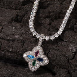 Multicolor four-leaf clover pendant displayed against dark textured wood