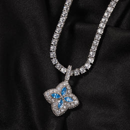 Aqua-blue four-leaf clover pendant displayed on black fabric