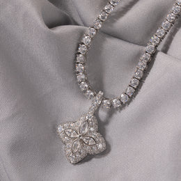 Clear-stone four-leaf clover pendant displayed on soft gray fabric