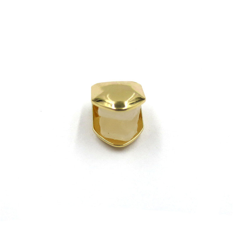 Gold-tone single tooth grill shown straight on with the open back visible