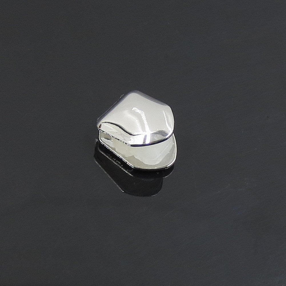 Silver-tone single tooth grill displayed on a dark reflective surface