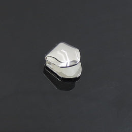 Silver-tone single tooth grill displayed on a dark reflective surface