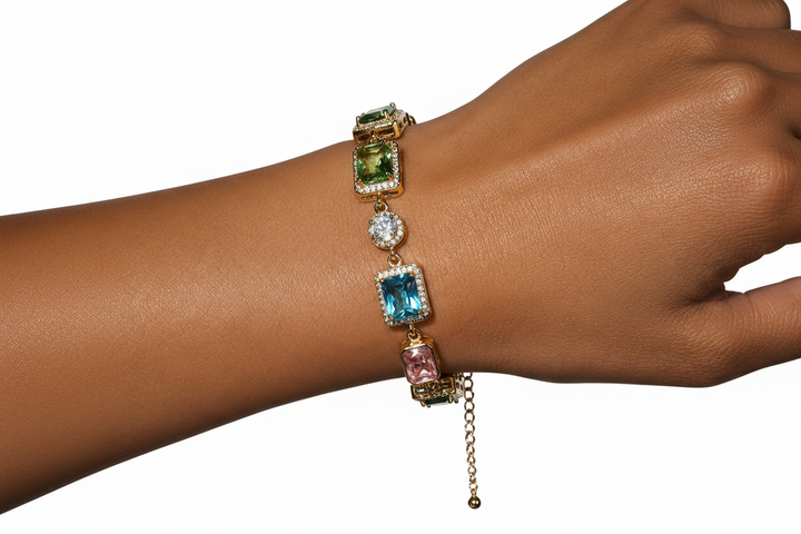 Gold-tone bracelet with multicolored stones in assorted shapes worn on the wrist