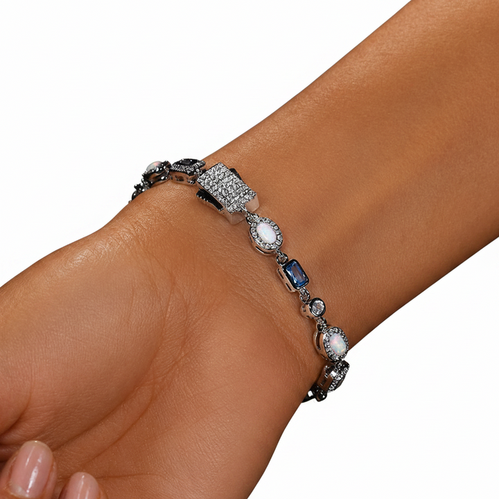 Silver-tone bracelet with blue and clear stones in assorted shapes worn on the wrist