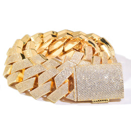 Gold-tone stone-set Cuban links coiled with a pavé box clasp on white
