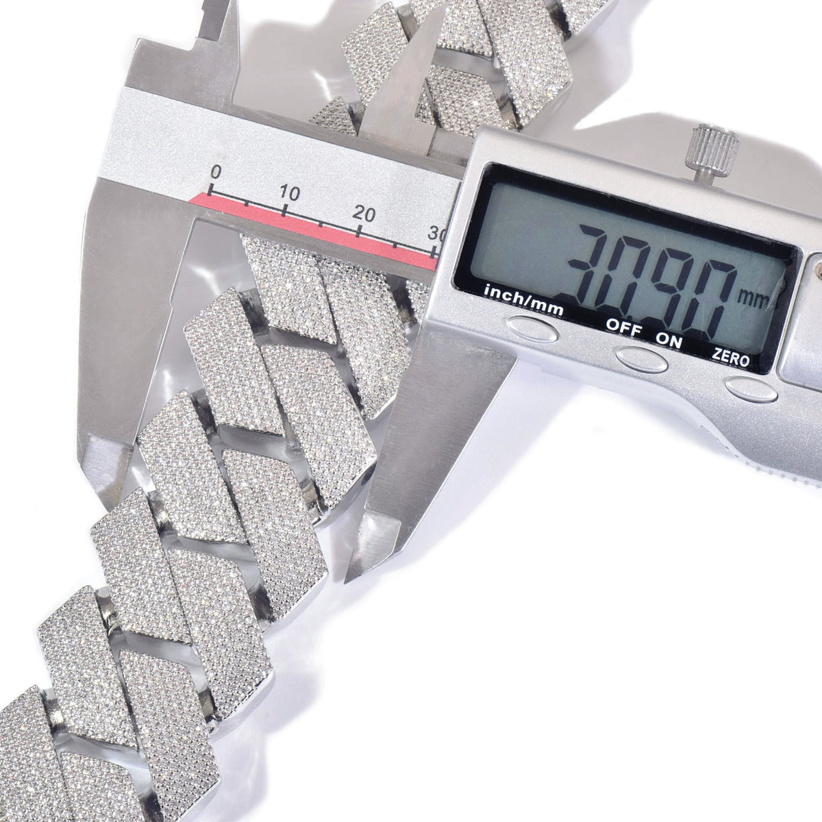Digital caliper measuring the width of silver-tone stone-set Cuban links