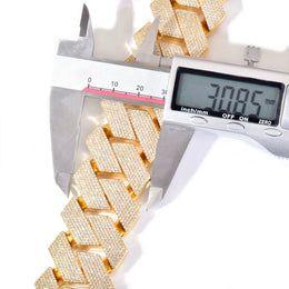 Digital caliper measuring the width of gold-tone stone-set Cuban links