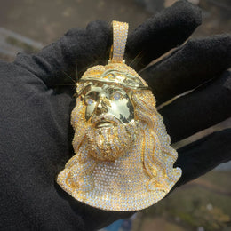 Gold-tone Jesus portrait pendant showing the polished face and stone-set beard