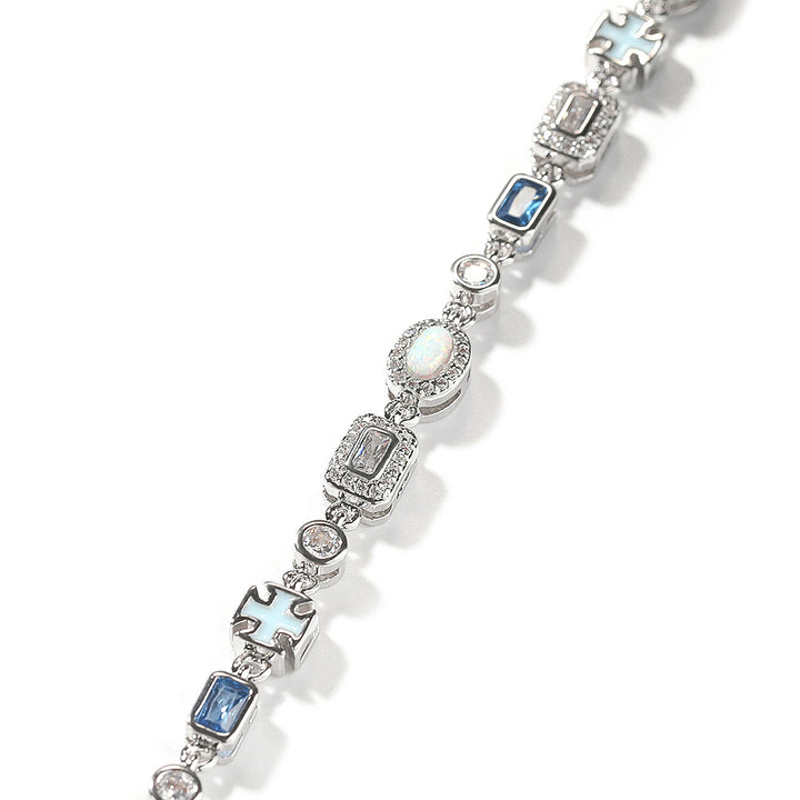 Close-up of silver-tone geometric links with blue and clear stones