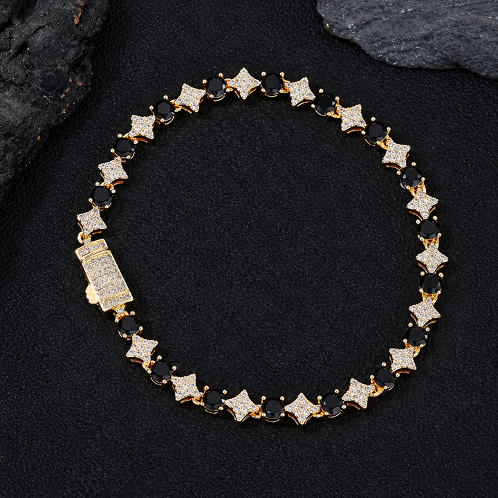 Gold-tone black round stone and clear star link bracelet with a box clasp on black fabric