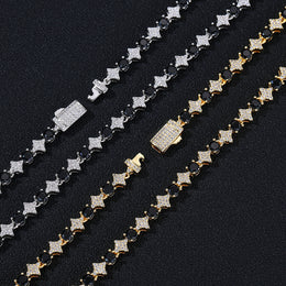Close-up of black round stones, clear pavé stars and box clasps in Silver and Gold finishes