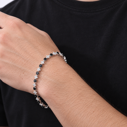 Adult model wearing a silver-tone black stone star tennis bracelet at the wrist