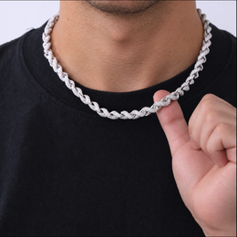 Close view of the rope necklace at the neckline, with a hand lifting a section of links