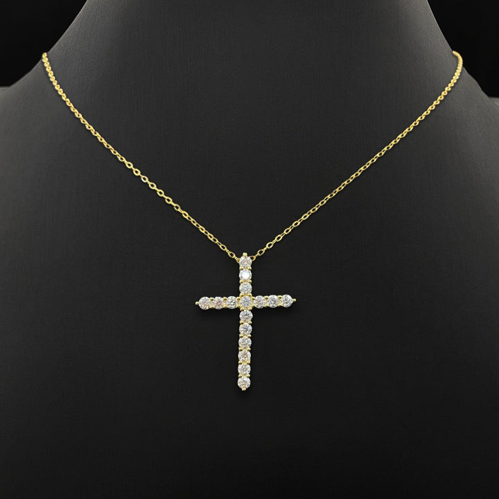 Gold-tone stone-set cross pendant on a fine chain displayed on a black bust