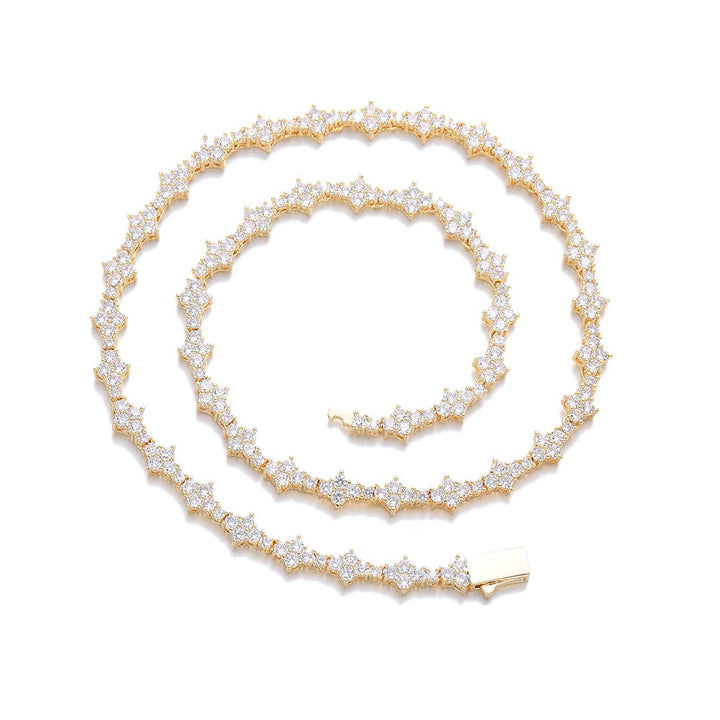 Gold-tone stone-set star-link necklace coiled on white