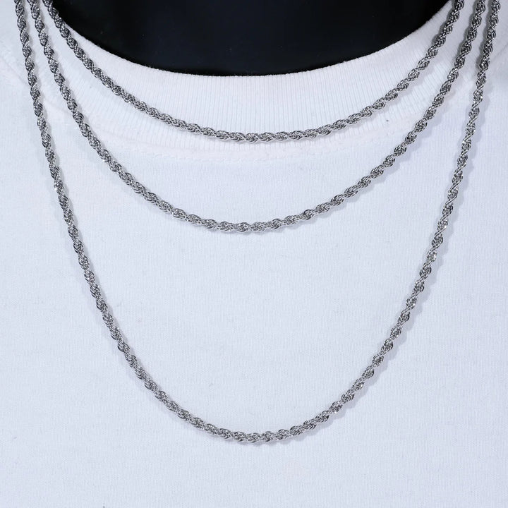 Silver-tone rope necklaces layered on a white display