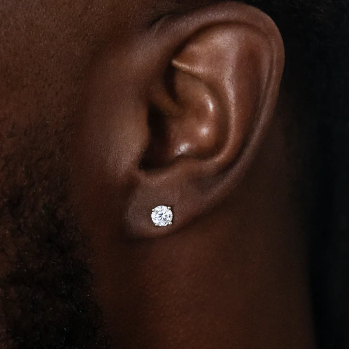 Round clear-stone stud earring worn on an earlobe
