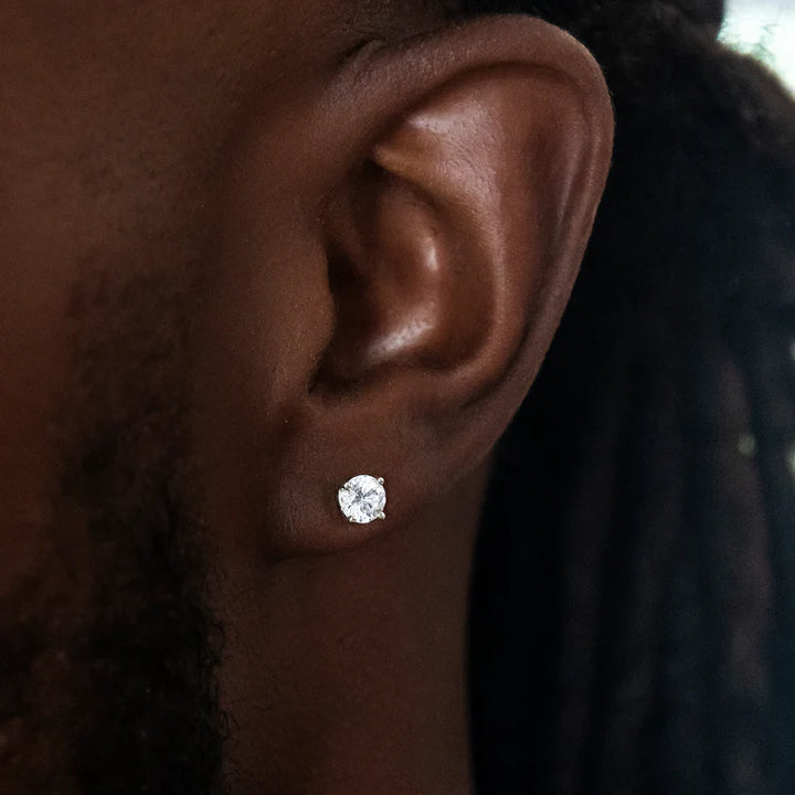 Round clear-stone stud earring worn on an earlobe
