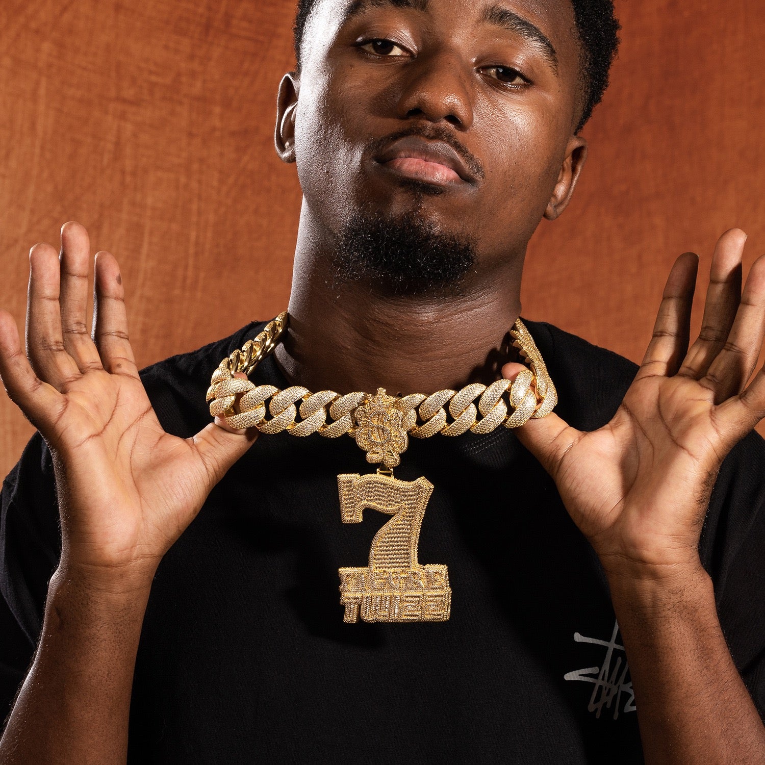 Model holding gold iced 7 Figure Twizz pendant
