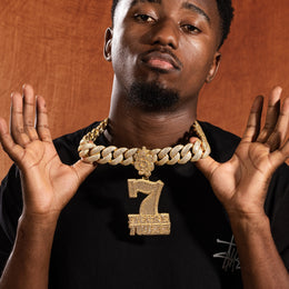 Model holding gold iced 7 Figure Twizz pendant