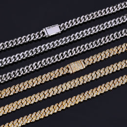 Silver and gold Cuban link chains with iced out clasps on black background - Miles Jewellery