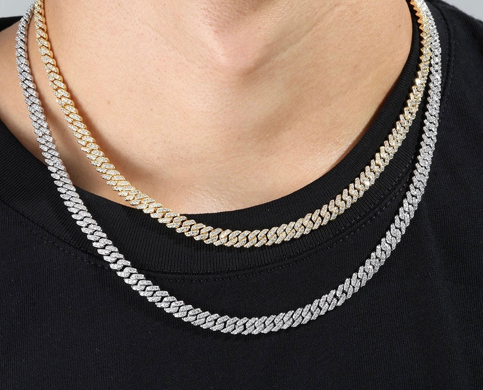 Two iced out Cuban link chains, one gold and one silver, worn over black shirt - Miles Jewellery