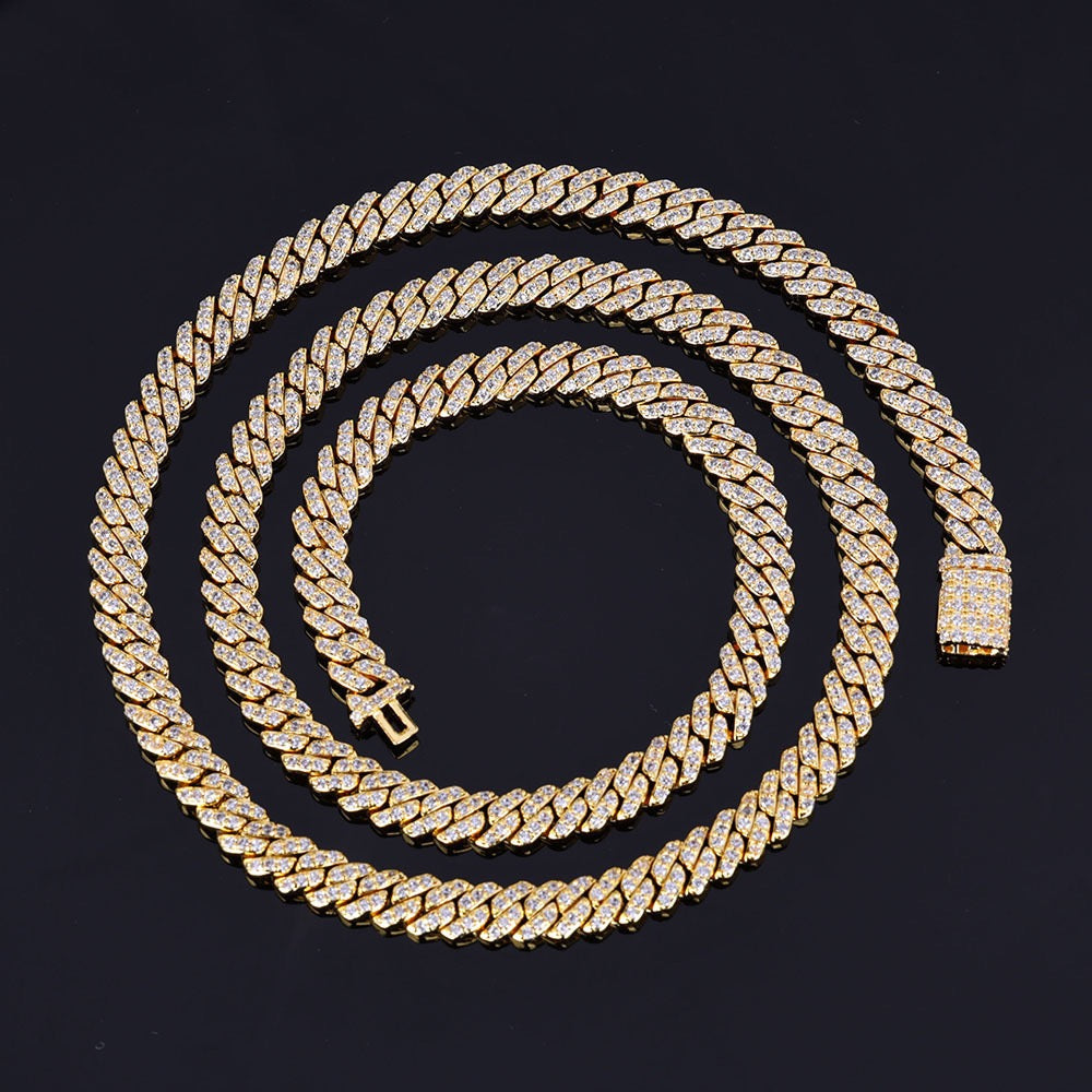 Gold Cuban link chain necklace with pavé stones on black background - Miles Jewellery