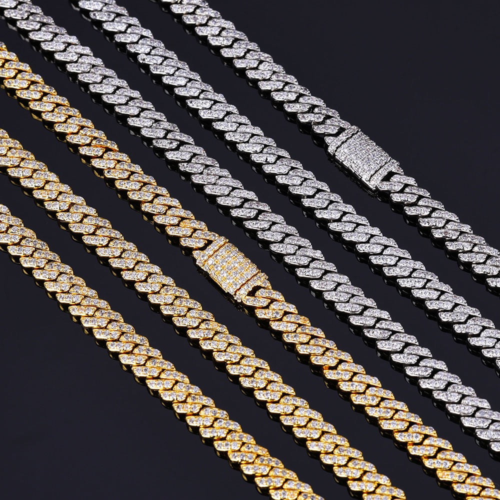 Gold and silver iced out Cuban link chains with diamond clasps on black background - Miles Jewellery