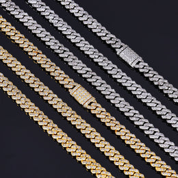 Gold and silver iced out Cuban link chains with diamond clasps on black background - Miles Jewellery