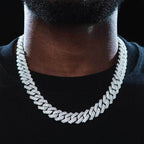 Close-up of a man wearing an iced out Cuban link chain necklace on black shirt - Miles Jewellery
