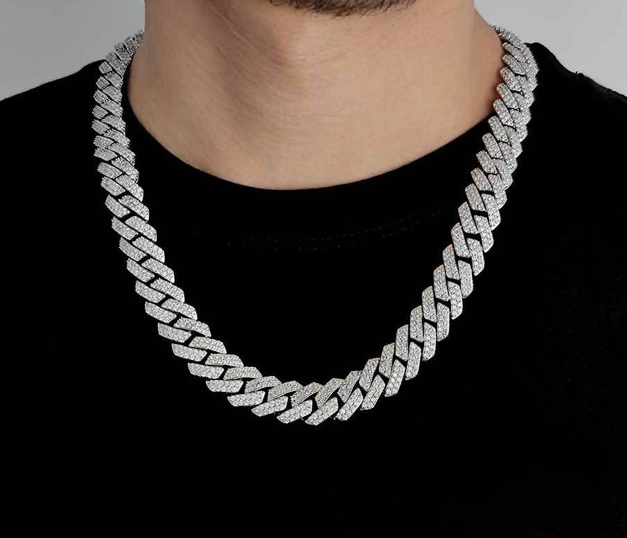 Man wearing a thick iced out Cuban link chain necklace on a black shirt - Miles Jewellery