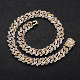 Gold Cuban link chain with pavé stones on black background - Miles Jewellery