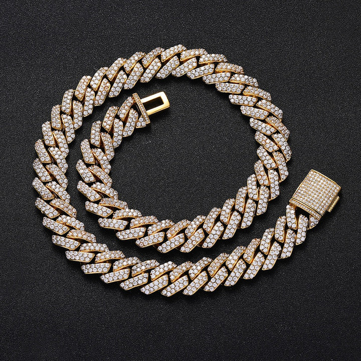 Gold Cuban link chain with pavé stones on black background - Miles Jewellery