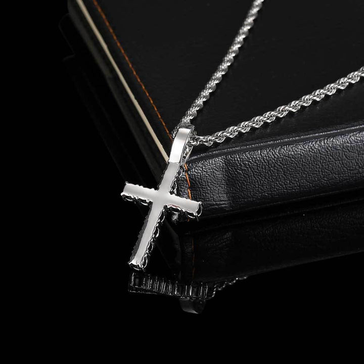 Silver-tone stone-set cross pendant and rope chain on a dark display