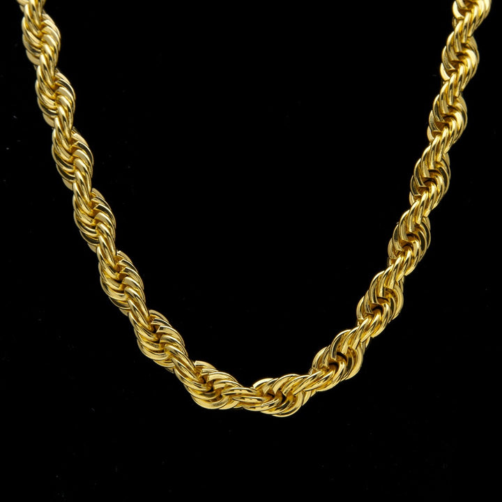 Close-up of a gold-tone rope necklace against black