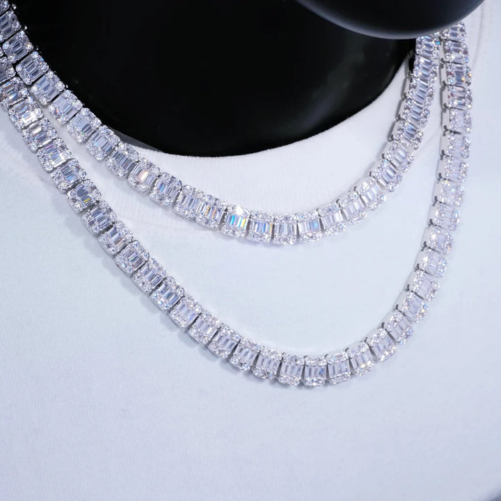 Two silver-tone rectangular-stone tennis necklaces on a white display