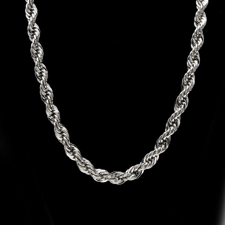 Close-up of a silver-tone rope necklace against black