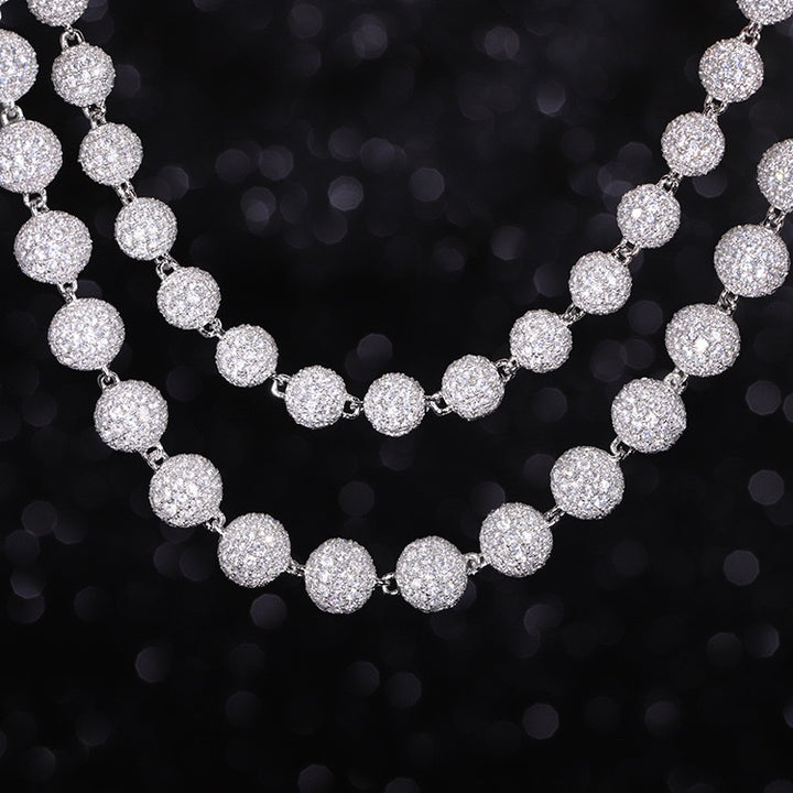 Silver-tone necklaces with round stone-set beads layered on a black display