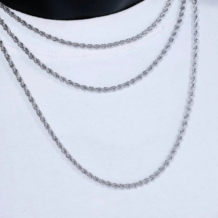 Silver-tone rope necklaces layered on a white display