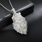 Silver floral pendant necklace on a dark surface